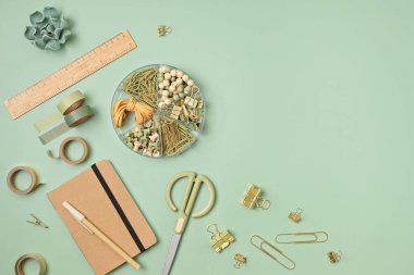 Flatlay of office supplies made of recycled materials on green background with copy space for text. Banner, flat lay, top view 