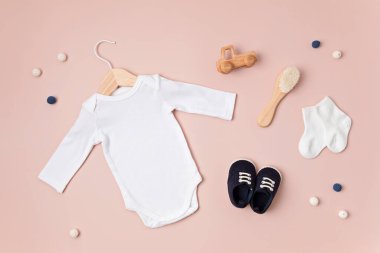 Çevre dostu bebek aksesuarlarıyla organik pamuktan yapılmış beyaz bebek tulumu. Marka, logo ve reklam için tulum şablonu. Düz yatış, üst görünüm