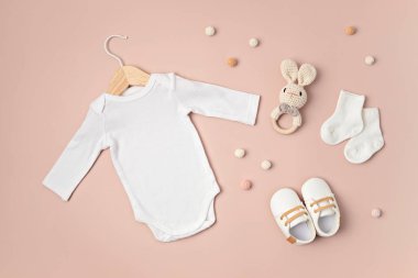 Çevre dostu bebek aksesuarlarıyla organik pamuktan yapılmış beyaz bebek tulumu. Marka, logo ve reklam için tulum şablonu. Düz yatış, üst görünüm