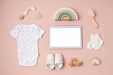 Organik pamuktan yapılmış, çevre dostu bebek aksesuarları ve beyaz ekranlı dokunmatik ped. Online markalaşma, dükkan, reklam için şablon. Düz yatış, üst görünüm