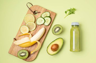 Sağlıklı taze avokado, kivi, muz ve çeşitli malzemelerle salatalık yeşili smoothie. Süper gıda detoksu ve diyet konsepti. Üst manzara, düz uzanma