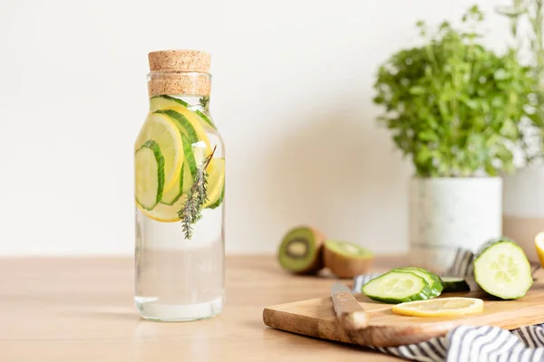 木製のテーブルの上にガラス瓶にキュウリ レモン タイムで水を注入しました ダイエット デトックス 健康的な食事 減量の概念 — ストック写真