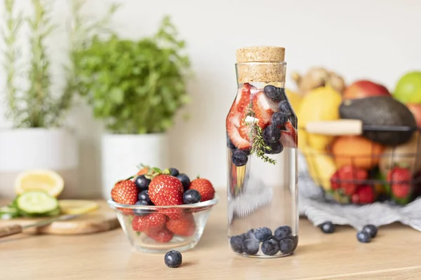 木製のテーブルの上にガラス瓶にイチゴとブルーベリーと水を注入しました ダイエット デトックス 健康的な食事 減量の概念 — ストック写真