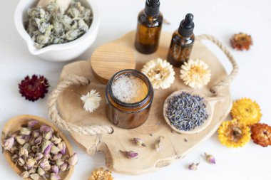 Botanik karışımlar, bitkiler, doğal yaşam için esanssal yağlar. Doğal ilaç, bitkisel ilaç, banyo için karışımlar ve ahşap masa arkasında çay.