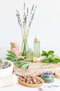 Botanik karışımlar, bitkiler, doğal yaşam için esanssal yağlar. Doğal ilaç, bitkisel ilaç, banyo için karışımlar ve ahşap masa arkasında çay.