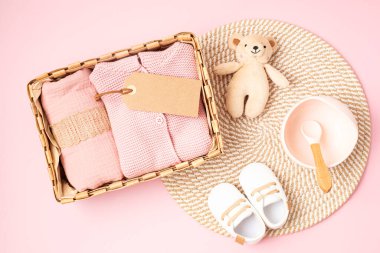 Cinsiyet ayrımı olmayan bebek kıyafetleri ve aksesuarlarıyla hediye sepeti. Yeni doğmuş organik ayakkabı, moda, markalaşma, küçük işletme fikri. Düz yatış, üst görünüm