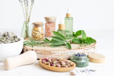 Botanik karışımlar, bitkiler, doğal yaşam için esanssal yağlar. Doğal ilaç, bitkisel ilaç, banyo için karışımlar ve ahşap masa arkasında çay.