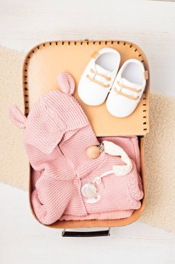 Cinsiyet ayrımı olmayan bebek kıyafetleri ve aksesuarlarıyla hediye sepeti. Yeni doğmuş organik ayakkabı, moda, markalaşma, küçük işletme fikri. Düz yatış, üst görünüm