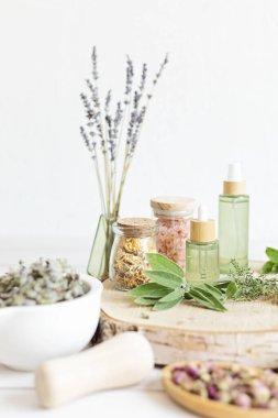 Botanik karışımlar, bitkiler, doğal yaşam için esanssal yağlar. Doğal ilaç, bitkisel ilaç, banyo için karışımlar ve ahşap masa arkasında çay.