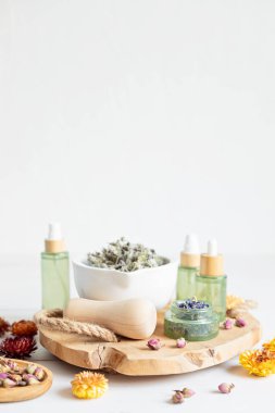 Botanik karışımlar, bitkiler, doğal yaşam için esanssal yağlar. Doğal ilaç, bitkisel ilaç, banyo için karışımlar ve ahşap masa arkasında çay.