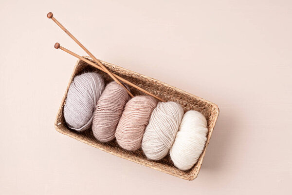 Craft knitting hobby background with yarn in natural colors. Recomforting hobby to reduce stress for cold fall and winter weather.