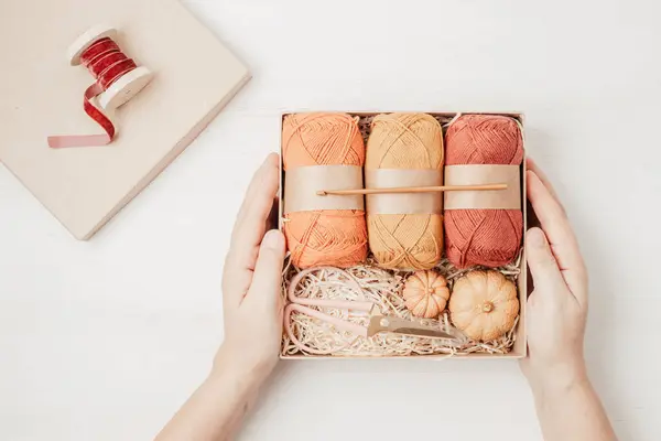 Preparing gift box for knitting lovers. Plastic free zero waste care package. Personalized eco friendly basket for family and friends for autumn holidays, christmas, mothers day