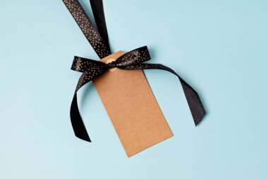 Mavi arka planda siyah kurdeleli boş bir etiket. Kara Cuma satış şablonu. Model, düz çizgi, üst görünüm