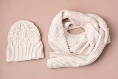 Pastel arka planda bej renkli yün şapka ve eşarp. Şık bir kadın dış giysisi. Kış aksesuarları