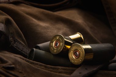 Pompalı mermiler yakın plan. Sırt çantasındaki haki rengi bez üzerinde yumuşak delikli silahlar için mühimmat. Koyu arkaplan.