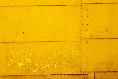 Eski paslı metal levhaların sarı dokuları perçin ve çivilerle birbirine bağlanmış..