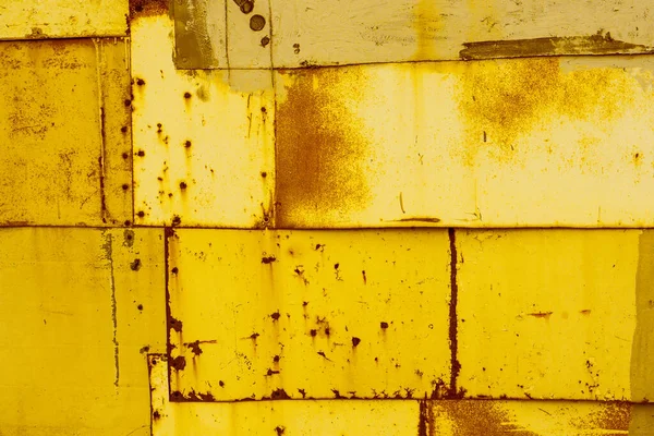 リベットや釘で固定された古い錆びた金属板の黄色の質感の背景 — ストック写真