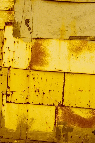 リベットや釘で固定された古い錆びた金属板の黄色の質感の背景 — ストック写真