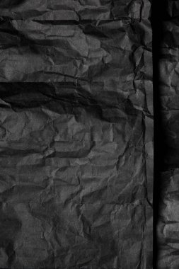 Siyah kırışık kağıt dokusu. Kaotik kıvrımlar ile koyu Kağıt arka plan. Siyah kırışık kağıt bir levha