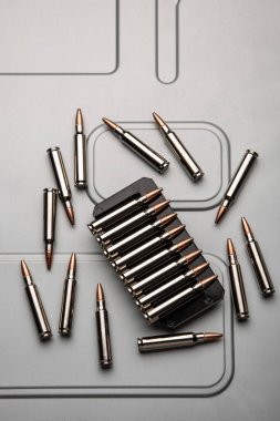 .223 kalibrelik gümüş kovanlar fırçalanmış metal üzerinde. Silahlar için mühimmat. Hafif arkaplan.