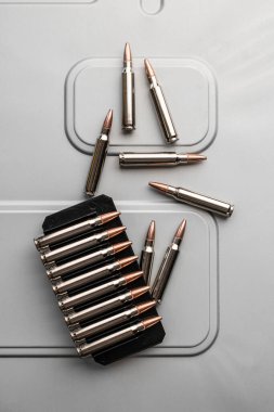 .223 kalibrelik gümüş kovanlar fırçalanmış metal üzerinde. Silahlar için mühimmat. Hafif arkaplan.