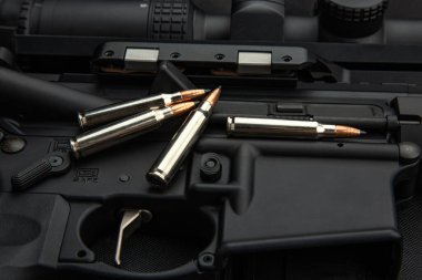 .223 'lük karabina mermilerine yakın çekim. Dolu şarjör. Silahlar arka planda.