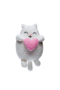 A cute, handmade, white crocheted cat holding a pink heart, perfect for Valentine's Day, gifts, or home decor. clipart