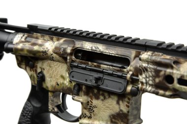 Kriptek kamuflajlı bir AR-15 üst alıcısının detaylı görüntüsü. Toz kapağı ve kabuk saptırıcıyı göstererek fırlatma portunu aç ve bitir.
