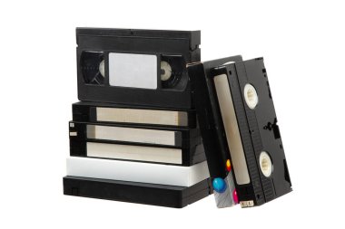 Beyaz arkaplanda eski VHS kasetleri yığını, etiketli ve renkli tasarımlı retro video kasetleri koleksiyonu.