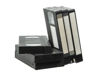 Birbirlerine yaslanmış, beyaz arkaplanda izole edilmiş, boş etiketli eski VHS kasetleri yığını