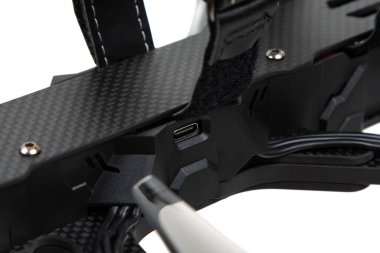 Karbon fiber FPV insansız hava aracı iskeleti üzerindeki USB-C portunun görünür kablolama ve yapısal ayrıntılara sahip yakın plan görüntüsü.