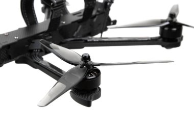 FPV drone pervanesinin ve karbon fiber koldaki motor montajının yakın plan görüntüsü bulanık arka plan.