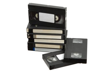Beyaz arkaplanda izole edilmiş boş etiketli klasik VHS kasetler yığını, nostaljik retro medya kavramı.