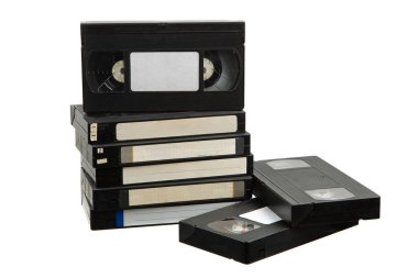 Beyaz arkaplanda izole edilmiş boş etiketli klasik VHS kasetler yığını, nostaljik retro medya kavramı.