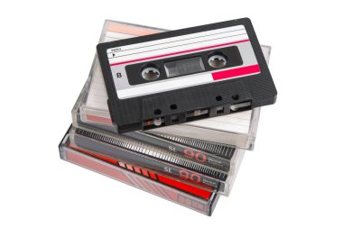Üst, açılı ve açısız, beyaz arkaplanlı retro ses kasetleri yığını.