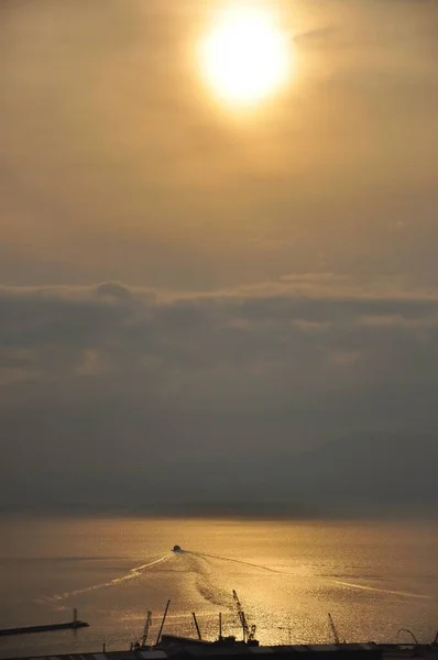 Liquid Gold Holiday boat. Sailing boat surrounded by sun glitters sea on beautiful sunset. Sailboat and panoramic view from Rijeka to Croatian island.