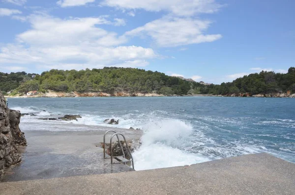 stock image The sea wave crashing on the rock and make the splashing water and white air foam bubble. Wave breaking on the beach.Breaking sea wave on the rocky coast,