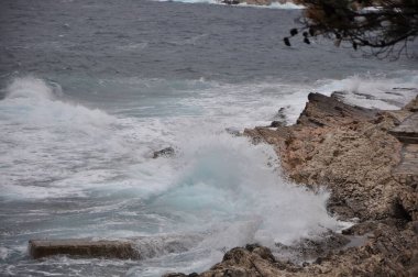 Mali Losinj sahil şeridinde kayalıklarda şiddetli dalgalar kopuyor. Hırvatistan 'daki Losinj adası, Avrupa' daki Nord sahili