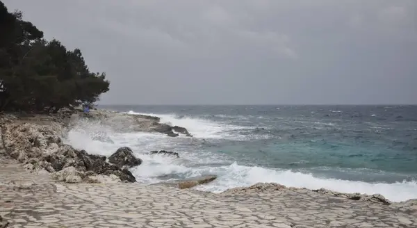 Huge Violent Waves Breaking on Rock Cliffs on Mali Losinj coastline. Losinj island in Croatia, Nord coast in Europe. Rolling Waves. Ocean Wave Curl Clean ocean wave rolling curling lip crashing on shallow coast