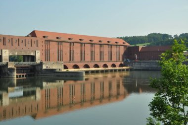 Passau, Bavyera, Almanya 09.2023. Passau 'daki Kachlet elektrik santrali Tuna Nehri' nde 1920 'lerden kalma çift kilitli ve hidroelektrik santrali olan bir baraj. Passau yakınlarındaki tuğlalardan yapılmış bir gemi iskelesi..