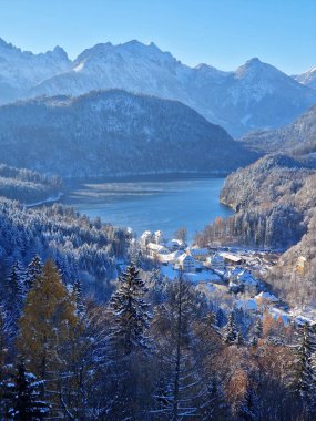 Almanya, Bavyera, Allgu, Hohenschwangau Kalesi ve Alpsee Gölü ile kış manzarası. Alpsee Gölü ve İsviçre Alpleri 'nin kış manzarası. Hohenschwangau Kalesi, köy ve Alpsee Gölü.. 