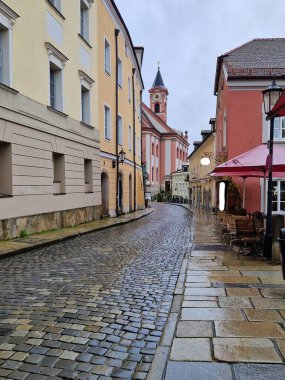 Eski Centar kenti Passau, Almanya 'nın Bavyera şehrinde yağmurlu bir günde eski asfalt cadde. Passau 'daki kaldırım taşı sokakları
