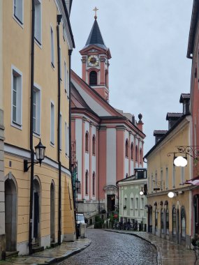 Eski Centar kenti Passau, Almanya 'nın Bavyera şehrinde yağmurlu bir günde eski asfalt sokak. Passau' da kaldırım taşı sokakları. St. Paul Kilisesi eski Passau, Almanya 'da.