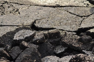 Asfalt yol yüzeyi yığını. Hasarlı asfaltla kaplı tehlikeli bir yol. Kanalizasyonun onarımı veya kazası kavramı. Çatlak asfalt, kuru dönem.
