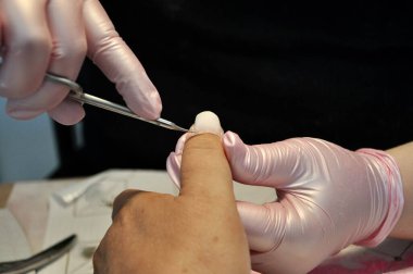 Manikürcü, kurbanın tırnağını kesmiş. Manikürden önce tırnakları hazırlamak, tırnak etlerini kesmek. Deri ve tırnak tedavisi. Güzellik salonu ve kaplıca. Manikür, kadın derisi kesme, güzellik uzmanına..