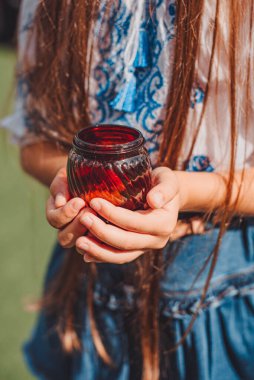 Nakışlı ceketli Ukraynalı bir çocuk savaşta ölen kahramanlar için mum tutuyor. Bir dakikalık saygı duruşu. Ukrayna için dua ediyoruz.