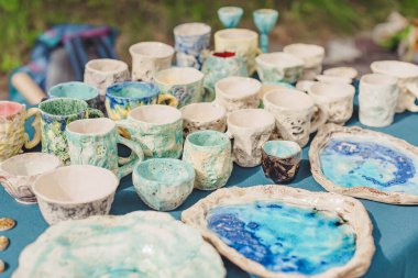El yapımı seramik, boş el yapımı seramik tabaklar, kupalar, kupalar ve kâseler bir sokak fuarında ya da bit pazarında ya da pazar pazarında. Seçici odak.
