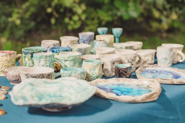 El yapımı seramik, boş el yapımı seramik tabaklar, kupalar, kupalar ve kâseler bir sokak fuarında ya da bit pazarında ya da pazar pazarında. Seçici odak.