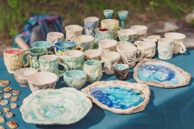El yapımı seramik, boş el yapımı seramik tabaklar, kupalar, kupalar ve kâseler bir sokak fuarında ya da bit pazarında ya da pazar pazarında. Seçici odak.
