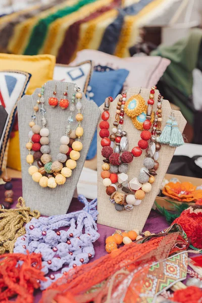 Hand made jewelry beads are made from old threads and other materials reused at the fair. Slow fashion, ecological craft production
